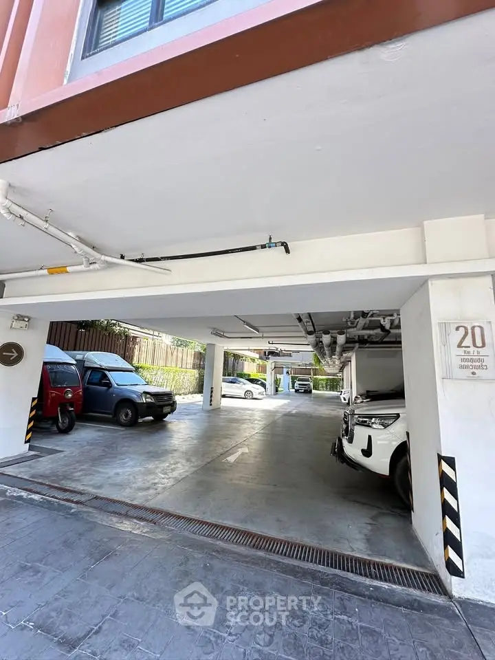 Spacious covered parking area with multiple vehicles in a modern residential building.