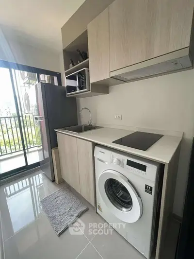 Modern kitchen with washing machine and open balcony view