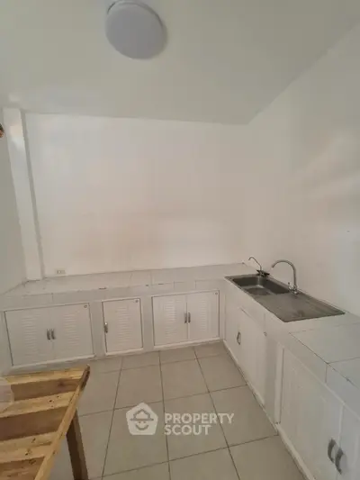 Minimalist kitchen with white cabinets and tiled countertops