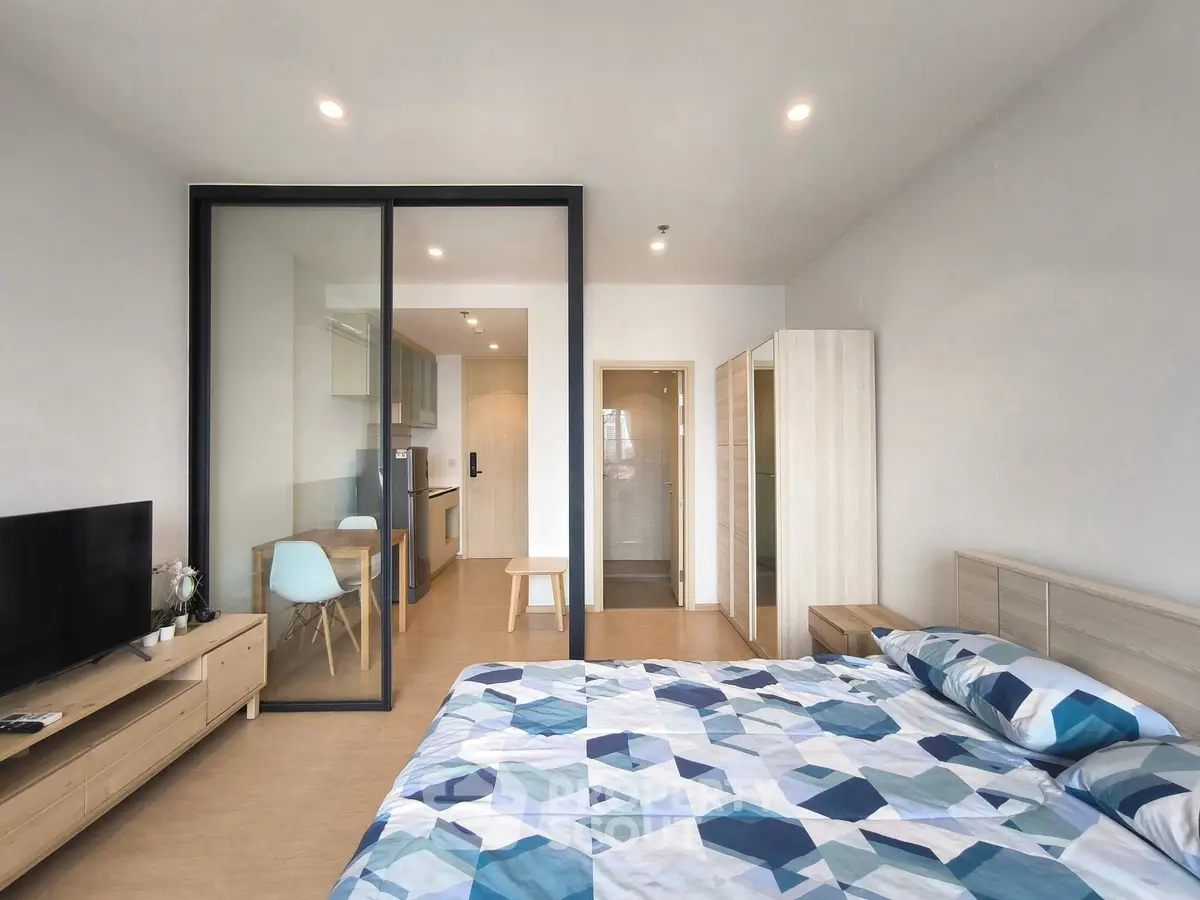 Modern studio apartment with open layout, featuring a cozy bedroom and sleek kitchen area.