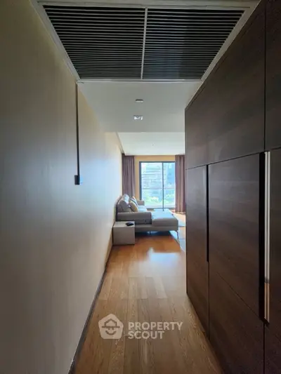Modern living room with wooden flooring and large window view