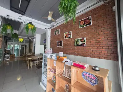 Charming restaurant interior with brick wall and wooden shelves, ideal for a cozy dining experience.