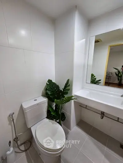 Modern bathroom with sleek fixtures and elegant plant decor