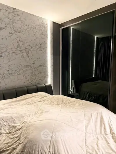 Luxurious modern bedroom with marble accent wall and sleek mirrored wardrobe.