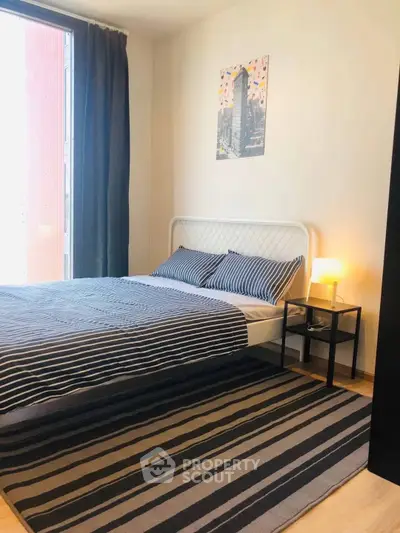 Modern bedroom with stylish decor and large window for natural light.