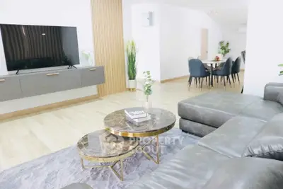 Spacious modern living room with sleek furniture and open dining area, perfect for entertaining.