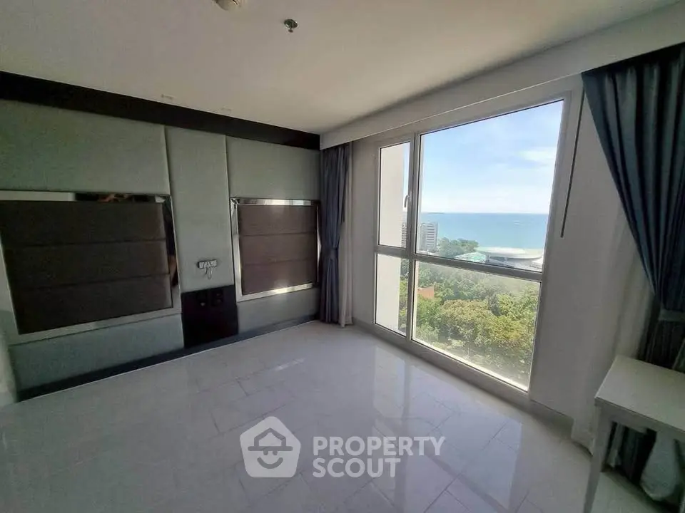 Spacious modern room with large window offering stunning ocean view, perfect for a serene living experience.