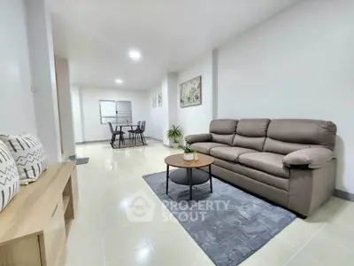 Spacious modern living room with cozy sofa and dining area in open layout.
