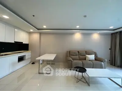 Spacious modern living room with sleek kitchen and cozy seating area, perfect for relaxation and entertaining.