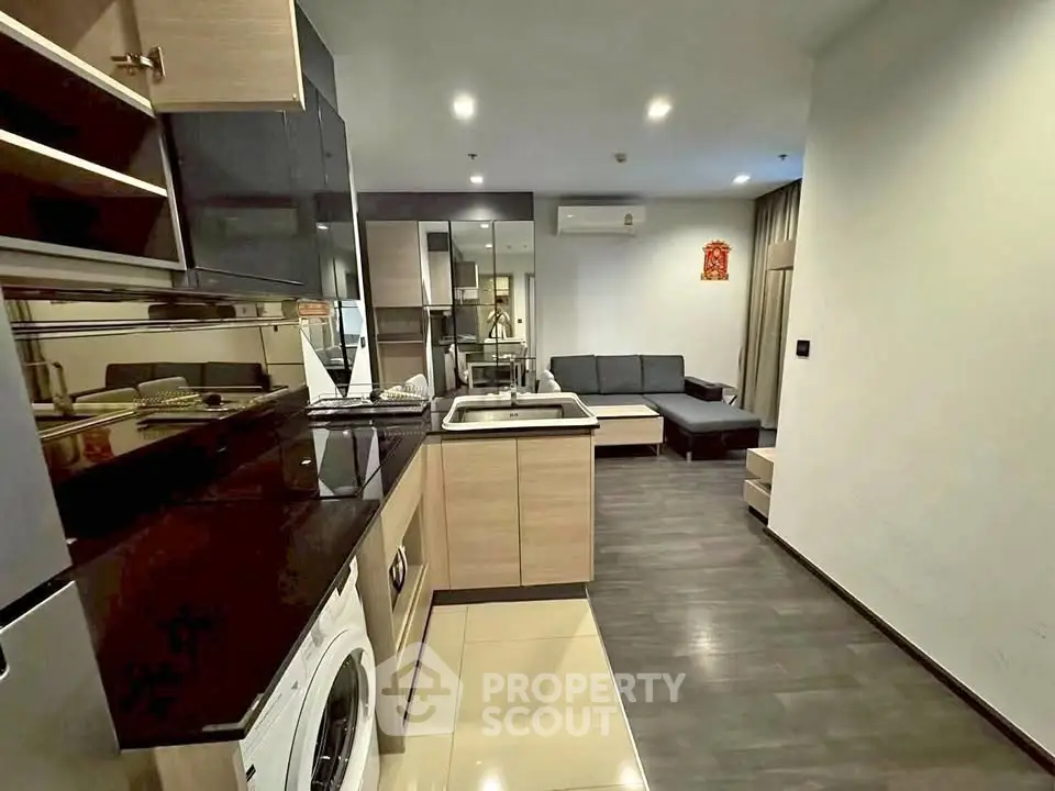 Modern open-plan living room with sleek kitchen and cozy seating area.