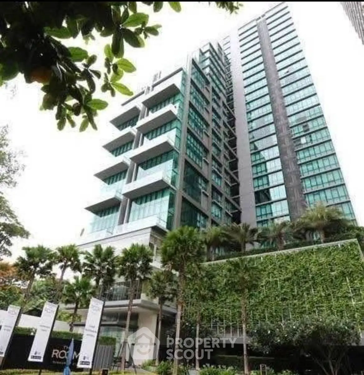 Stunning modern high-rise building with lush greenery and spacious balconies.