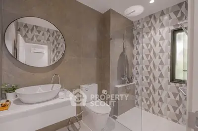 Modern bathroom with geometric tiles and glass shower enclosure