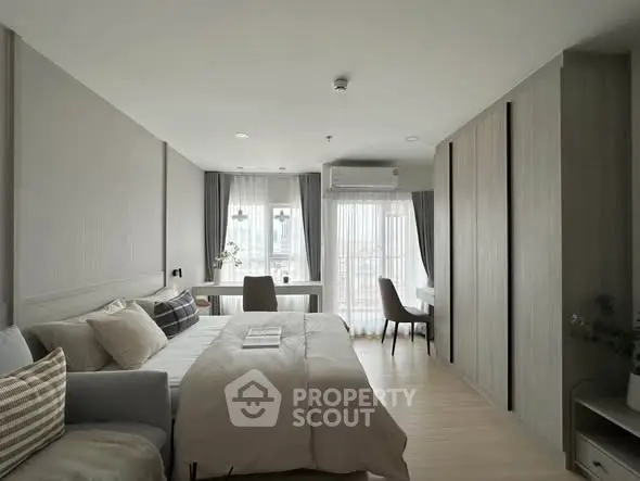 Modern bedroom with stylish decor and large windows offering natural light