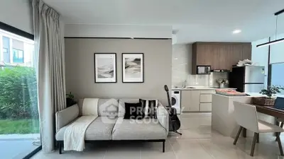 Modern open-plan living room and kitchen with stylish decor and natural light.