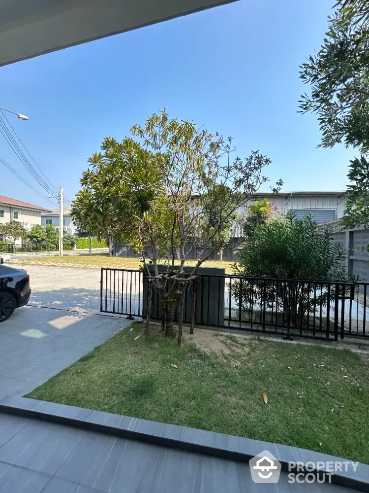 Spacious and serene outdoor view from a covered patio, showcasing lush greenery and a well-maintained lawn, perfect for tranquil living.