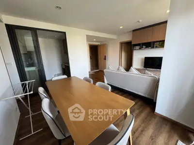 Modern living room with dining area, featuring sleek furniture and wooden flooring, perfect for contemporary living.