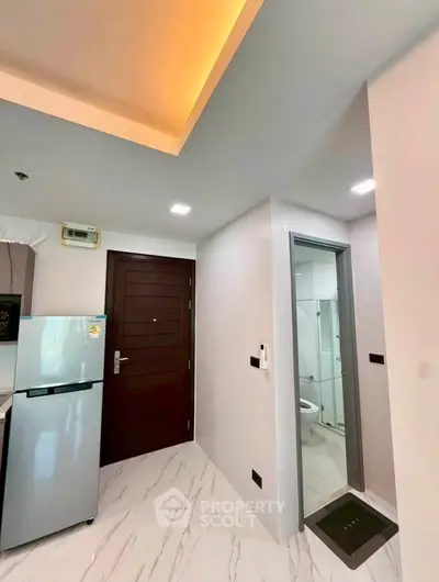Modern apartment entrance with sleek kitchen and bathroom view