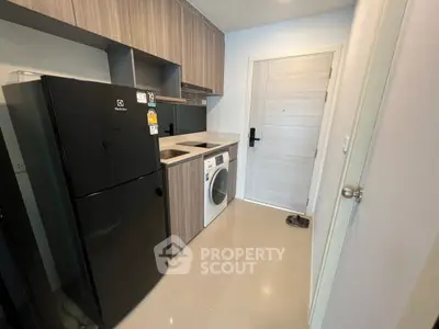 Modern kitchen with sleek appliances and stylish cabinetry in a compact layout.