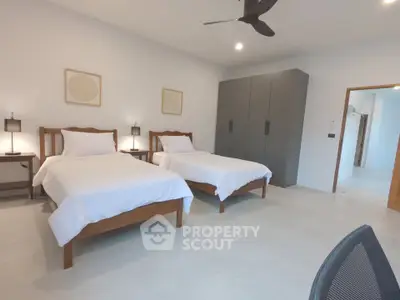 Spacious modern bedroom with twin beds and sleek wardrobe