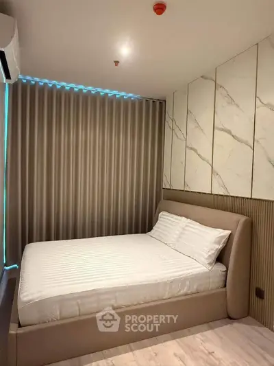 Modern bedroom with stylish decor and ambient lighting, featuring a comfortable bed and elegant wall design.