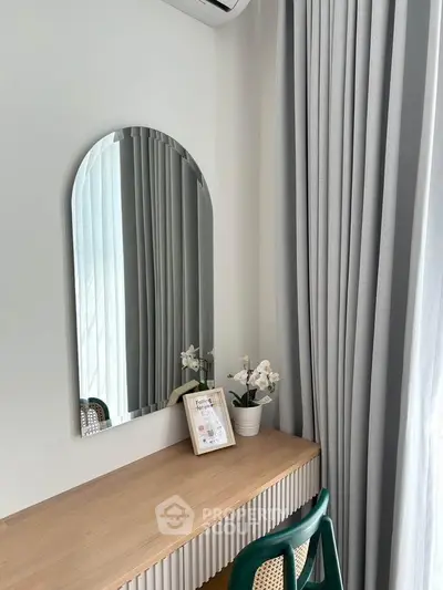 Stylish study nook with modern desk, mirror, and elegant decor in a bright interior space.