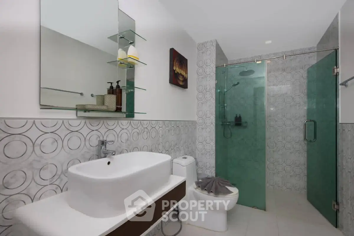 Modern bathroom with glass shower and stylish sink in contemporary home.