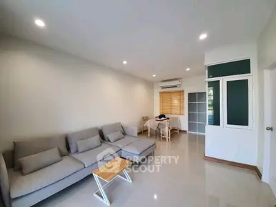 Spacious living room with modern gray sofa and dining area