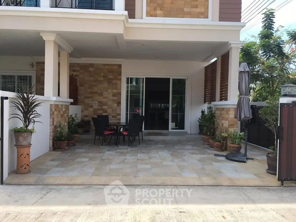Charming house exterior with spacious patio and stylish outdoor seating area.