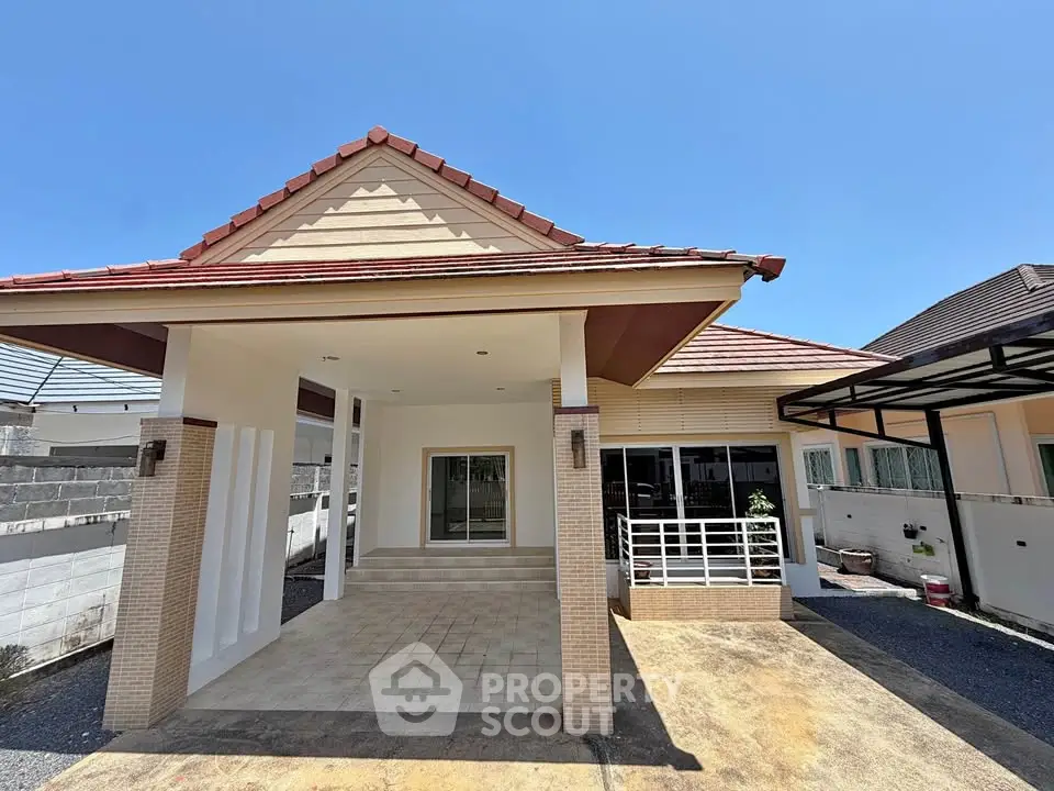 Charming single-story house with spacious carport and modern exterior design under clear blue sky.