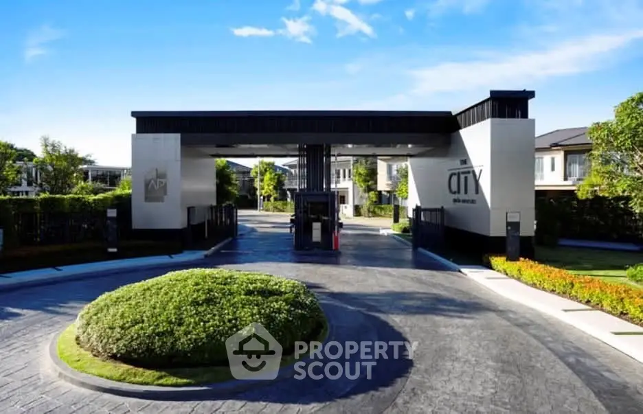 Luxurious gated community entrance with modern architecture and lush landscaping.