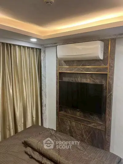 Luxurious bedroom with modern TV setup and elegant curtains
