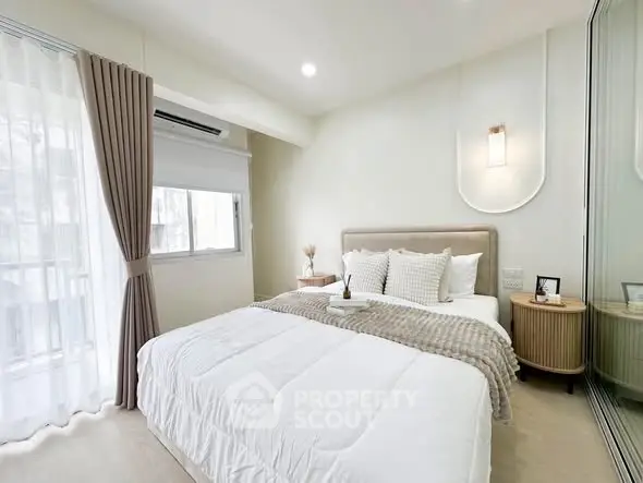 Bright and cozy bedroom with modern decor and large window for natural light.