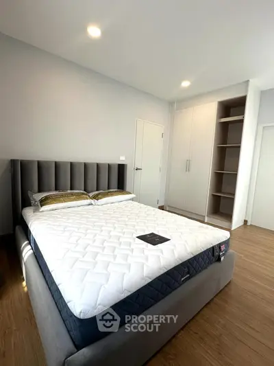 Modern bedroom with stylish bed and built-in wardrobe, perfect for cozy living.
