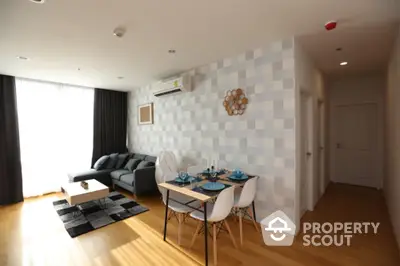 Modern living room with stylish decor and dining area in open layout apartment.