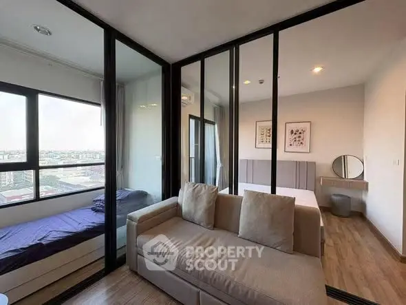 Modern apartment with glass partition, cozy living area, and city view.