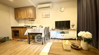 Charming living room with cozy dining area and modern kitchen in open layout apartment.