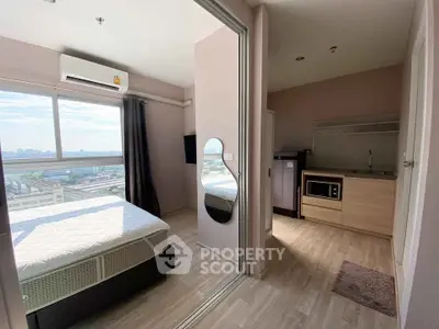 Modern studio apartment with city view, featuring a cozy bedroom and compact kitchen area.