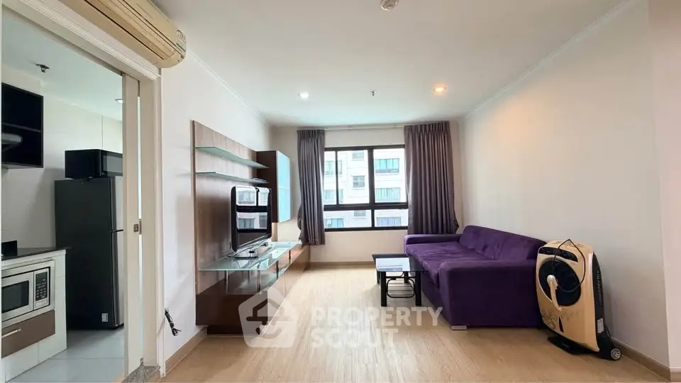Modern living room with purple sofa and entertainment center in a bright apartment