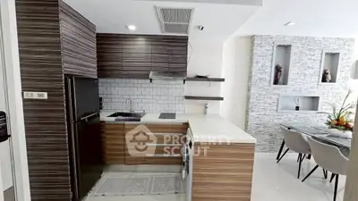 Modern kitchen with sleek cabinetry and dining area in stylish apartment