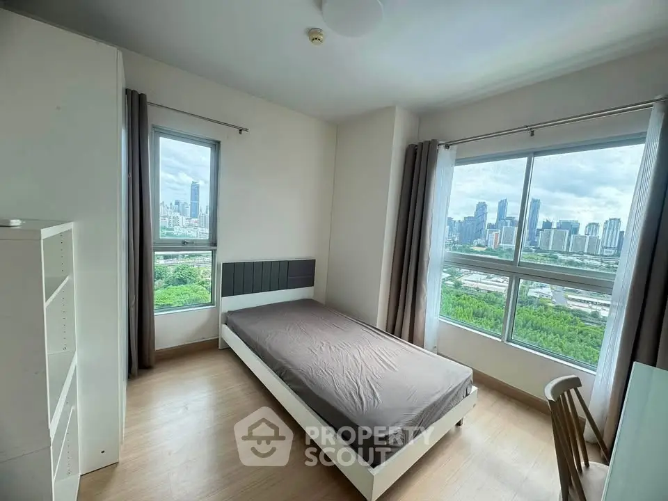 Modern bedroom with stunning city view and large windows in high-rise apartment