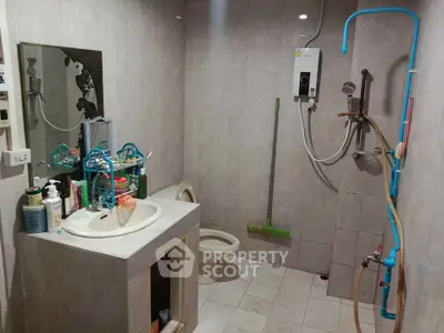 Functional bathroom with shower and sink in a tiled setting