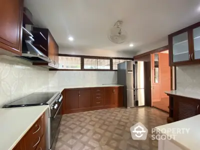 Spacious kitchen with modern appliances and wooden cabinetry