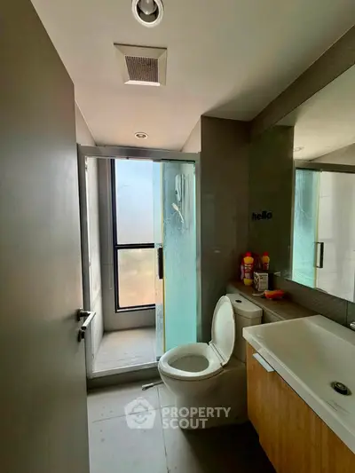 Modern bathroom with glass shower and sleek fixtures in contemporary apartment.