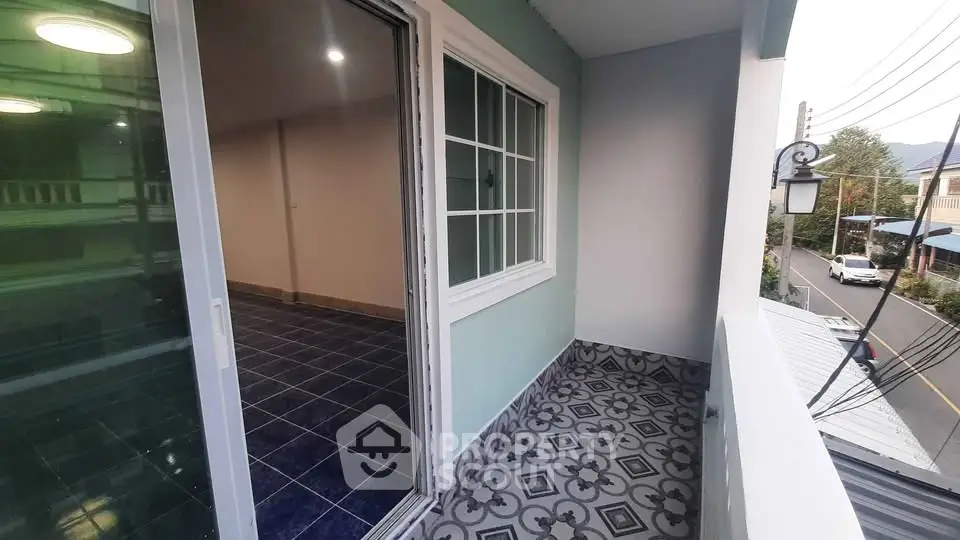 Charming balcony with patterned tiles and sliding glass door, perfect for relaxation.