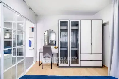 Modern bedroom with sleek wardrobe and stylish vanity in a bright, minimalist design.