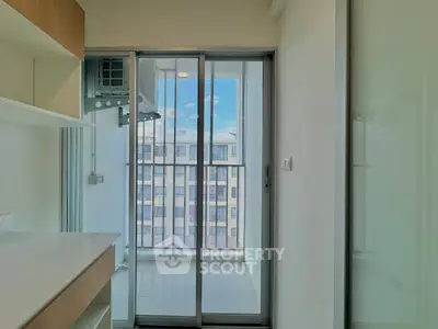 Modern apartment balcony with sliding glass doors and city view