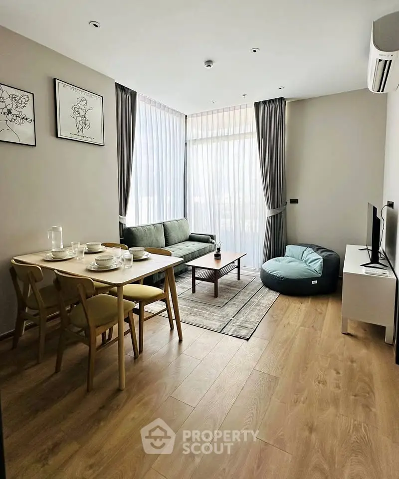 Modern living room with stylish decor, large windows, and cozy seating area in a contemporary apartment.