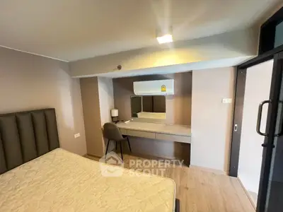 Modern bedroom with stylish decor and built-in desk, featuring a comfortable bed and sleek air conditioning unit.