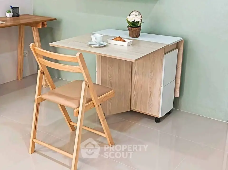 Chic modern study area with foldable wooden desk and chair, perfect for compact living spaces.