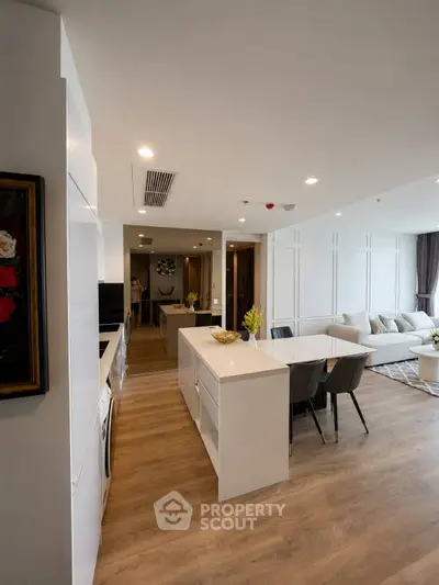 Modern open-plan kitchen and living room with sleek design and wooden flooring.